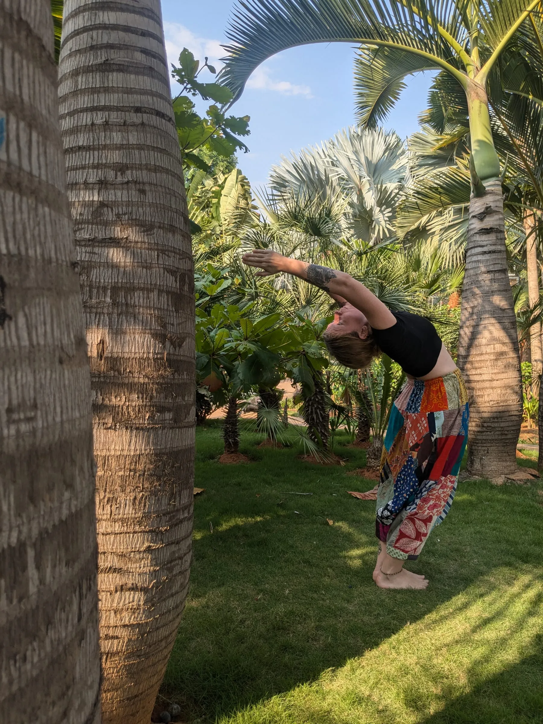 Laura en flexion latérale dans un jardin tropical